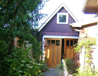 Inviting side-hinged carriage doors on this detached carriage house create a storybook cottage feeling.