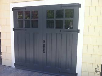 Beautifully painted Olympic style door on a shingle sided carriage house garage.